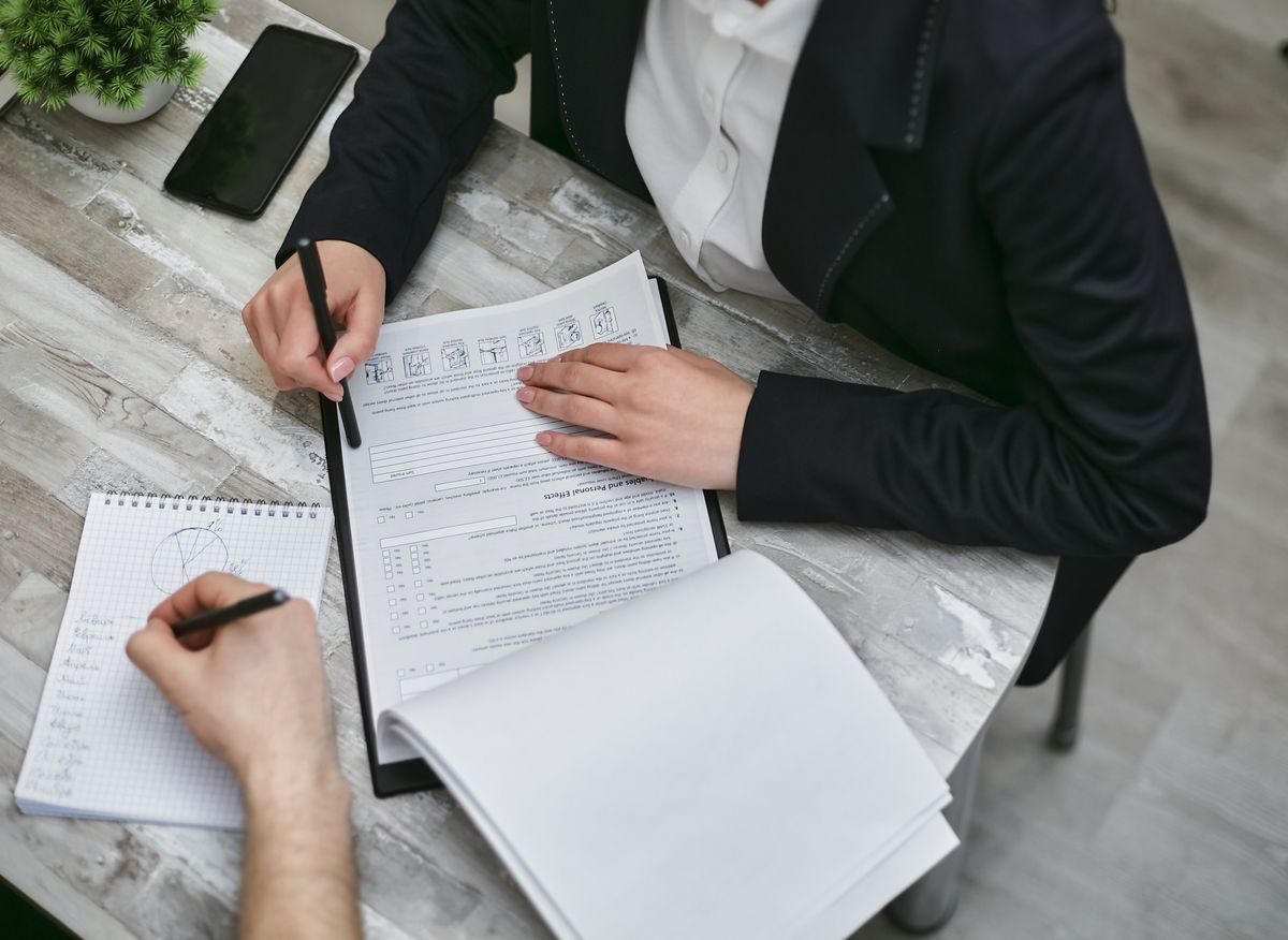 A car buyer reviewing the numbers on a used-car purchase with a dealership finance representative