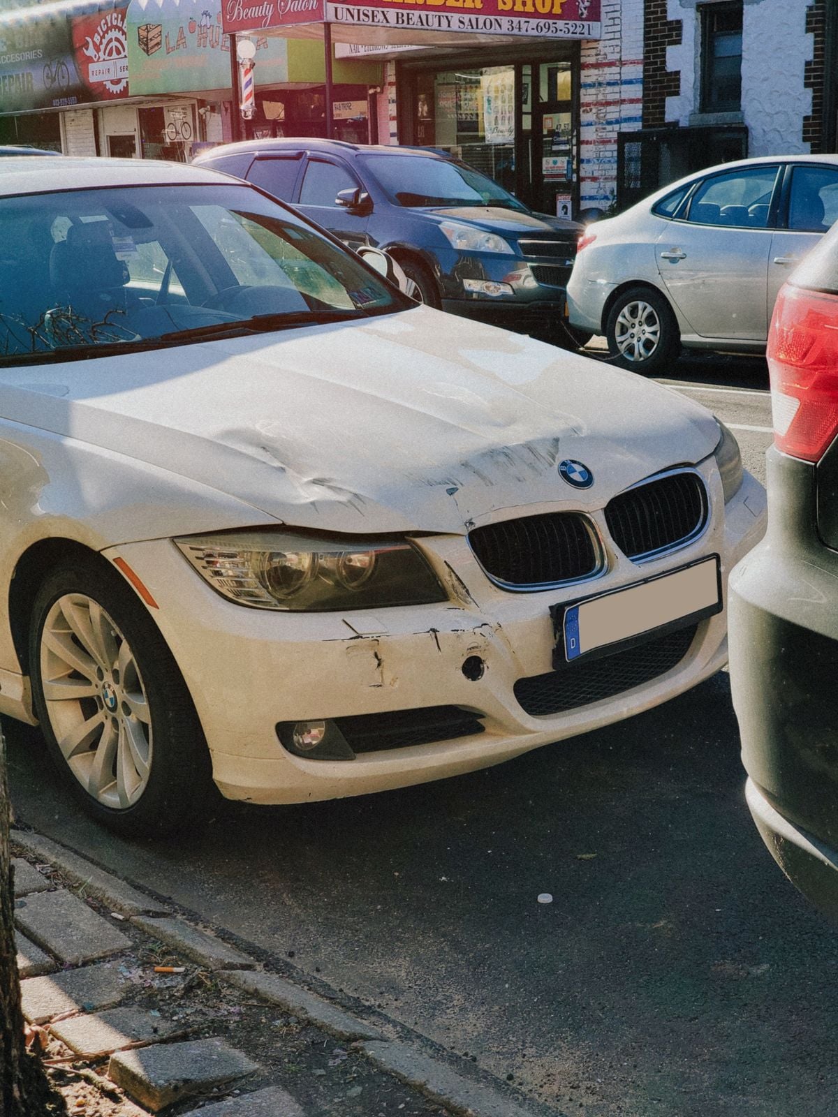 A car with visible front-end collision damage to the hood and bumper